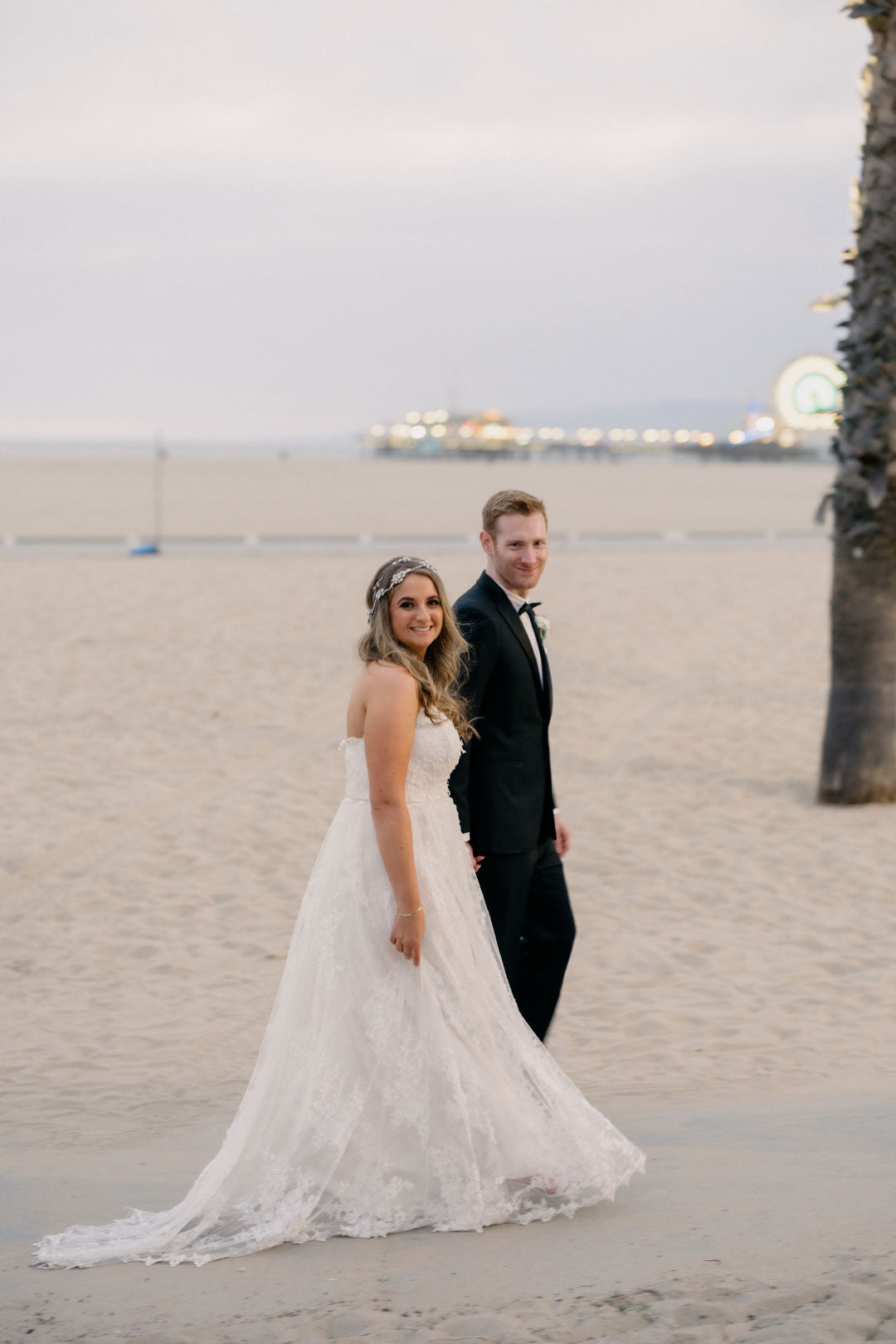 Bride and groom stroll at beach
