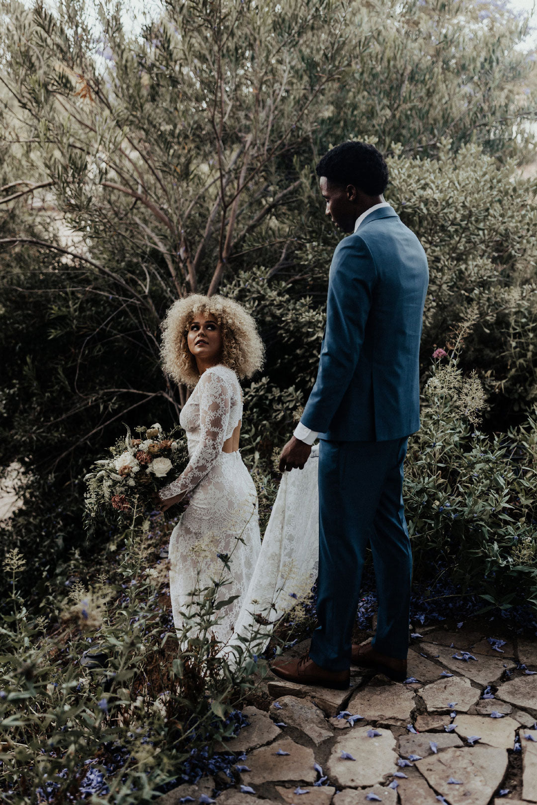 Bride and groom walking in garden 