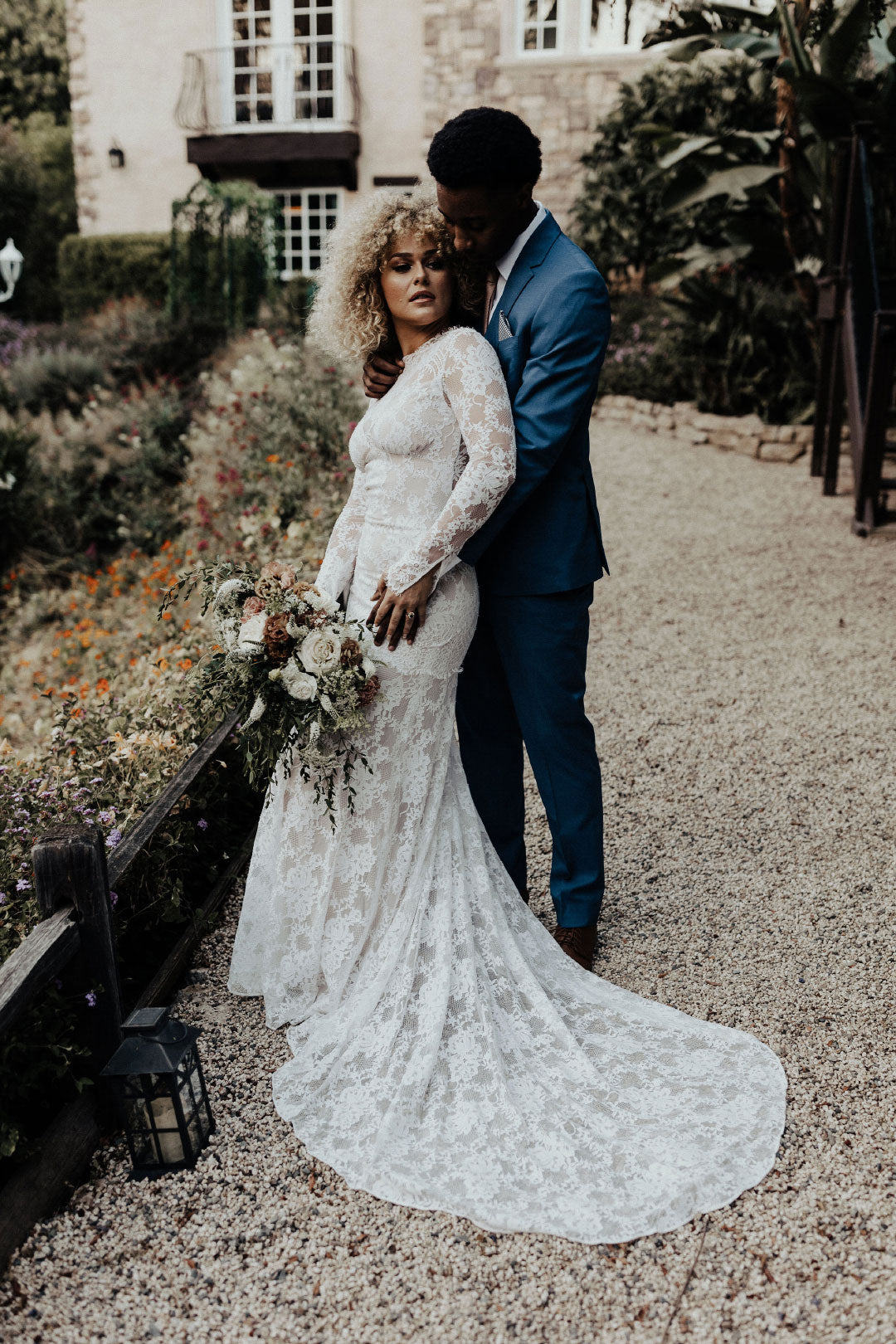 Bride and groom embrace an hug in garden