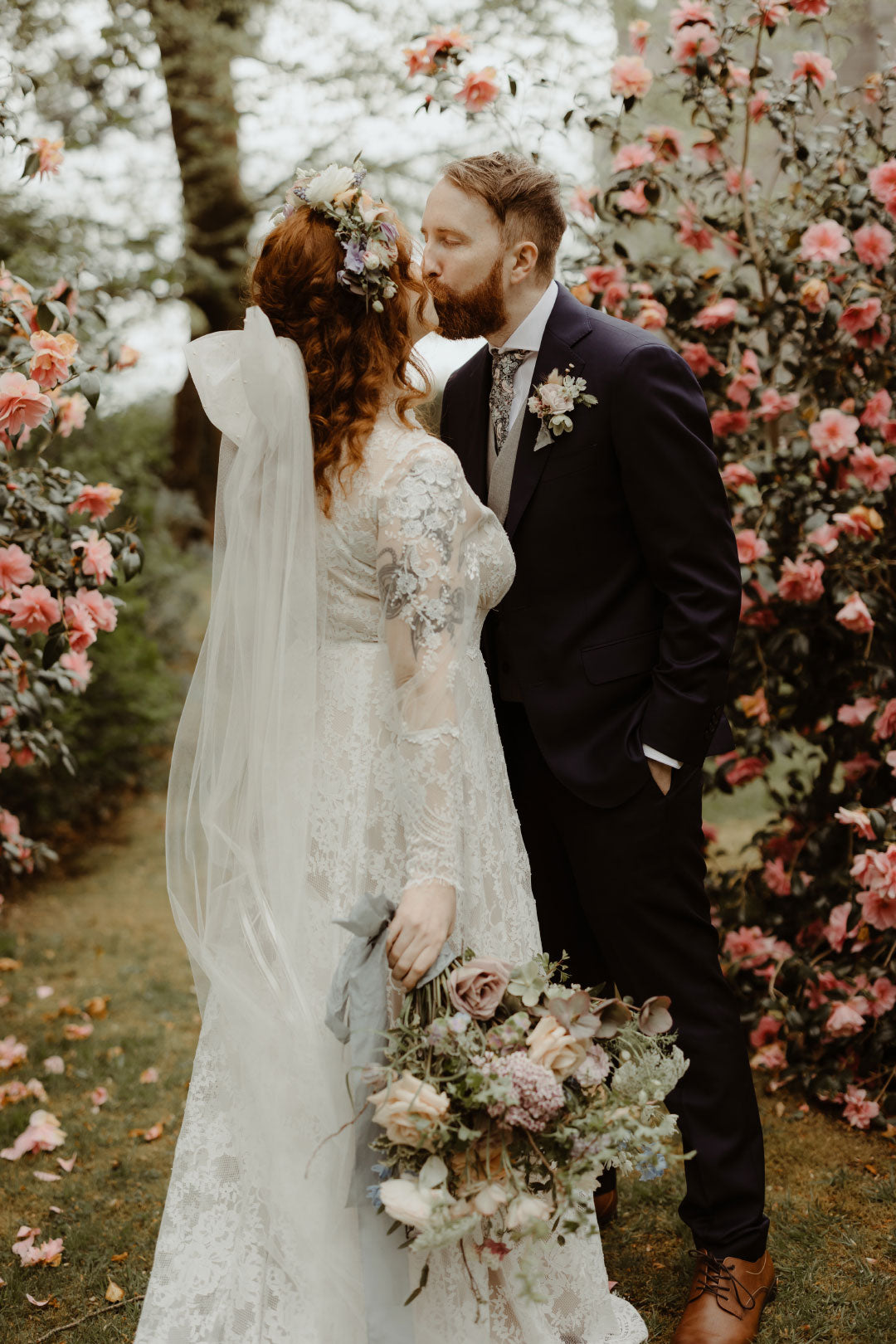 Bride and groom kissing in wedding venue garden