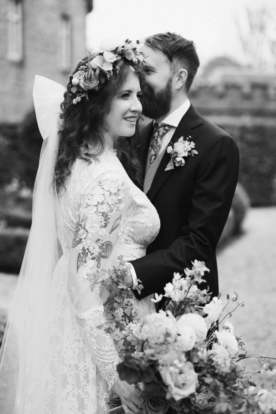 Black and white photo of bride with groom holding wedding bouquet