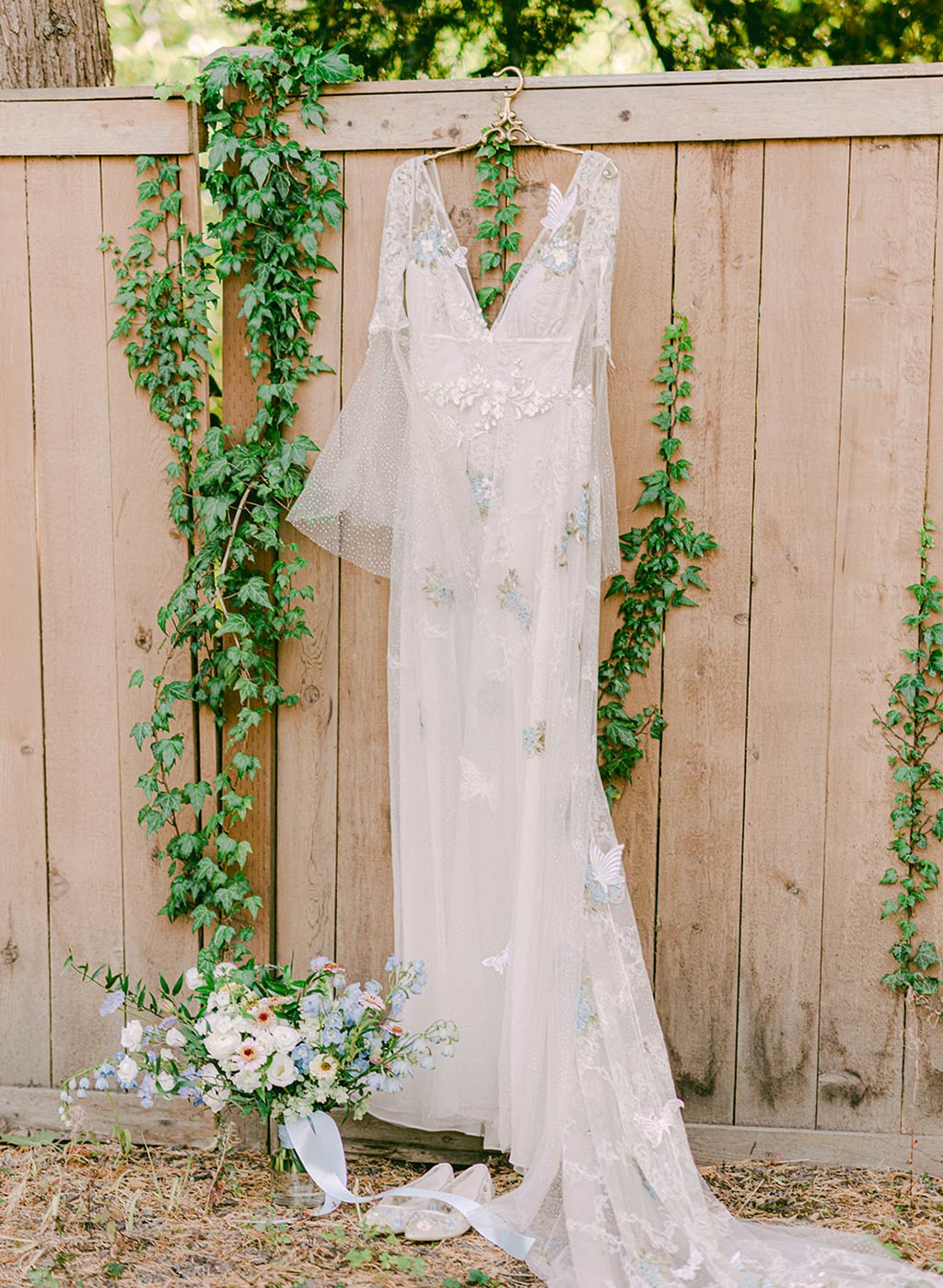 Chrysalis Wedding Dress on Hanger in Garden Setting