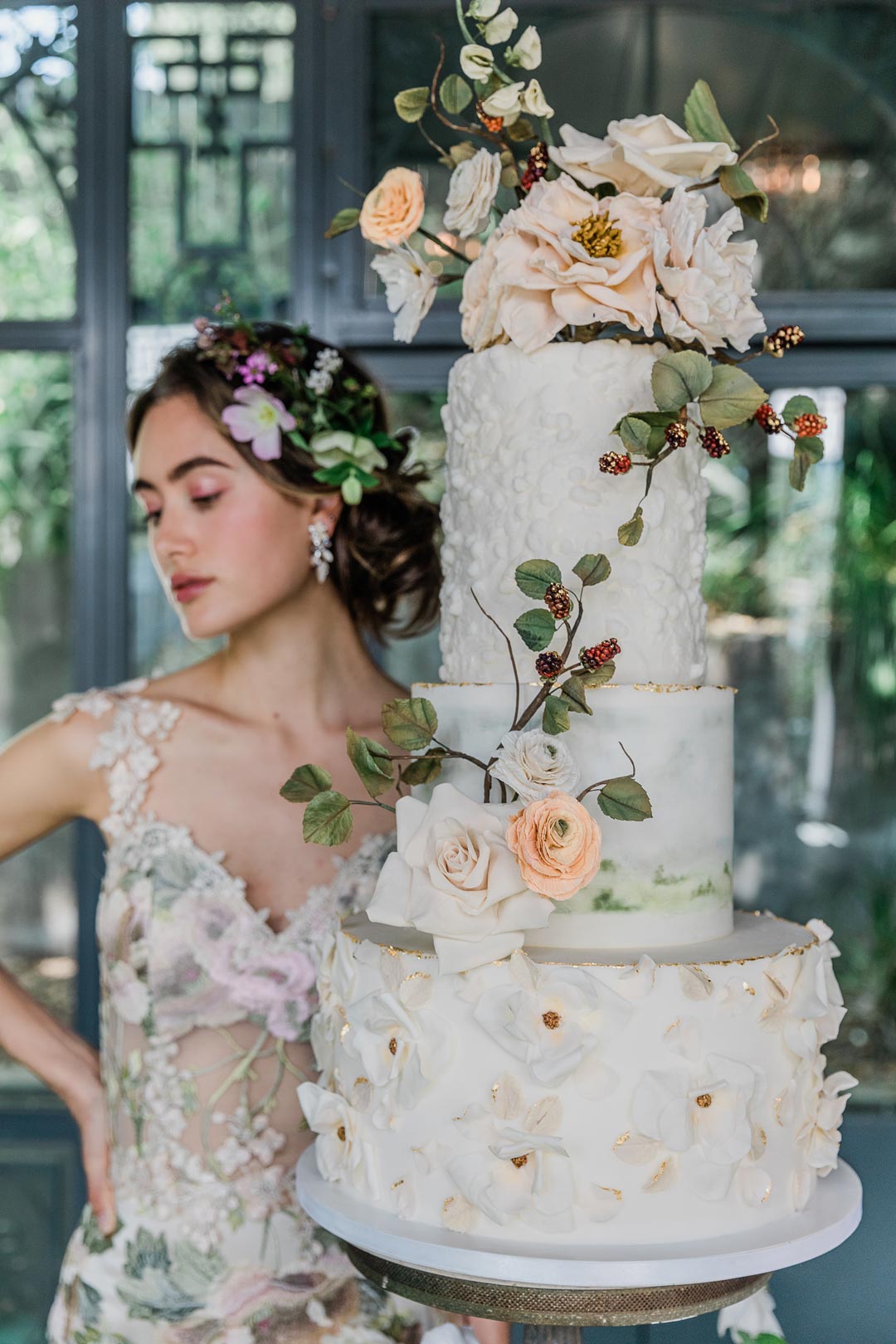 Model in Claire Pettbone Wedding Dress design with floral wedding cake design