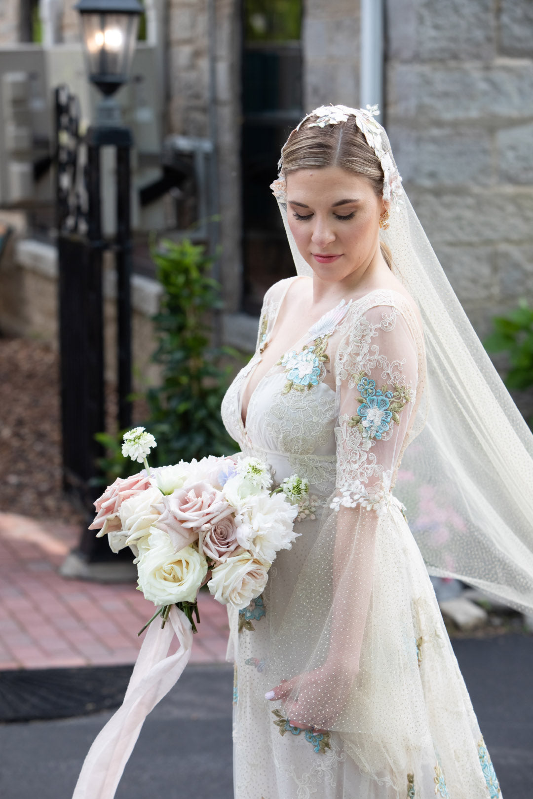 Bride holding wedding flower bouquet wearing Chrysalis wedding dress with bell sleeves