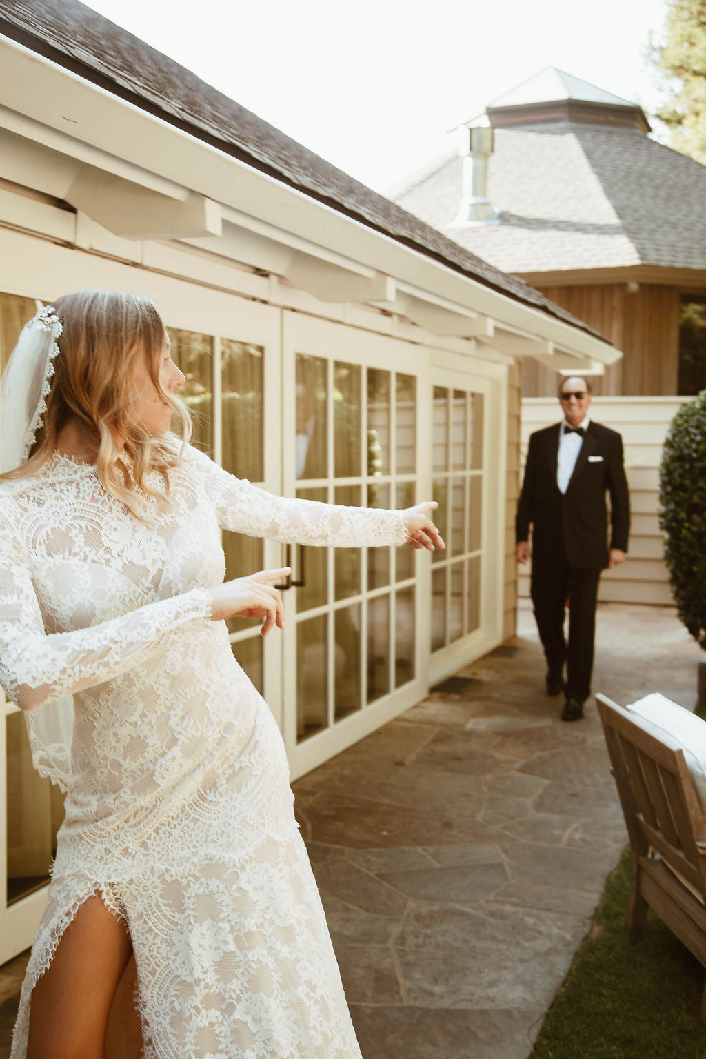 Bride pointing to Father wearing lace wedding dress