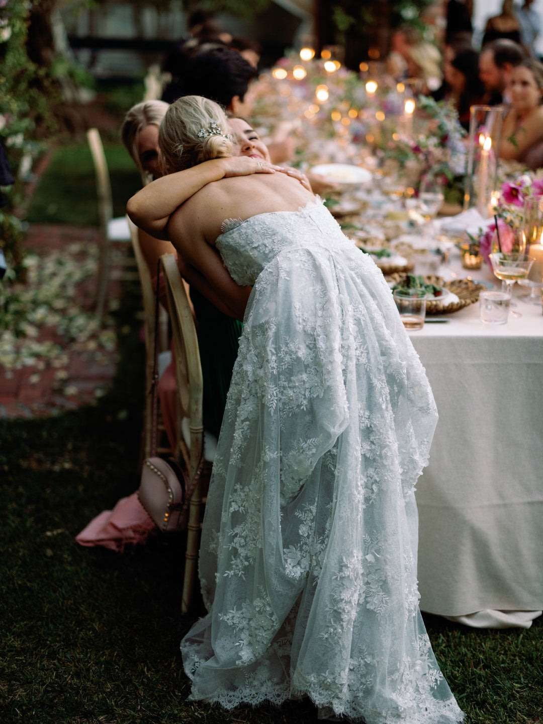 Bride Anais in wedding dress hugging guest