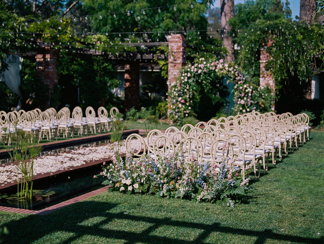 Wedding Ceremony chairs on lawn with wedding floral arraignments