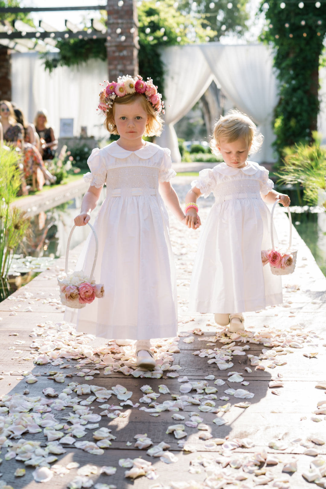 Flower girls walking the aisle flower petals on ground