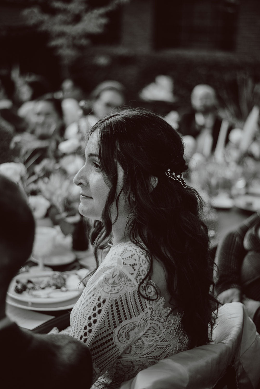 Bride at wedding dinner listening to speaker