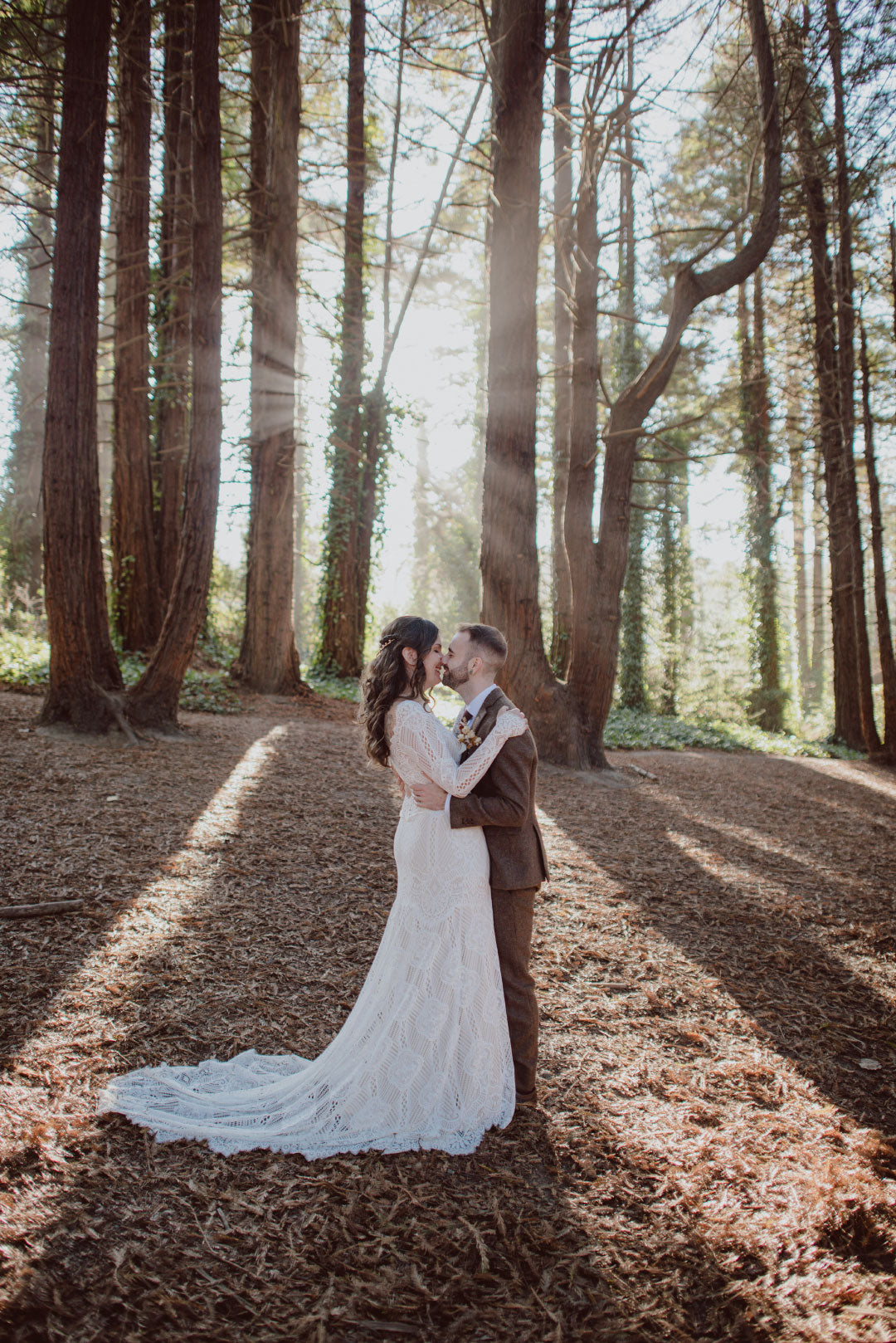 Bride and Groom in forrest with sunbeams streaming through trees