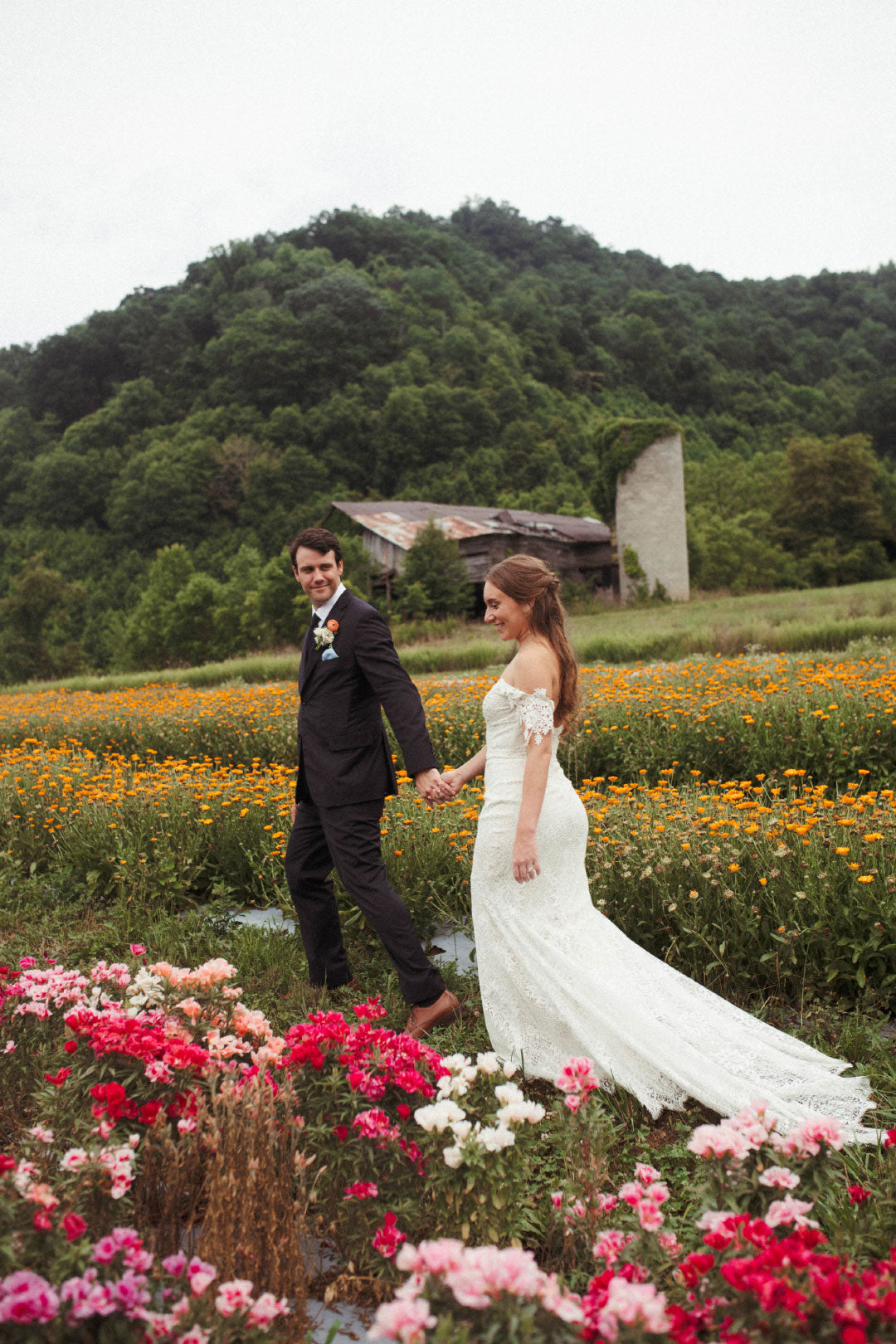 Bride and Groom walking in wildflower field