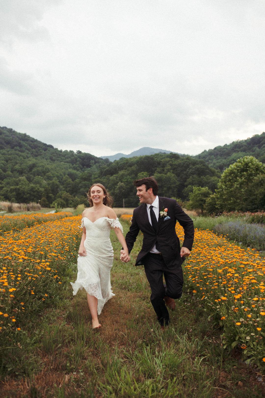 Bride and Groom Running in Wildflower field Wedding protrait