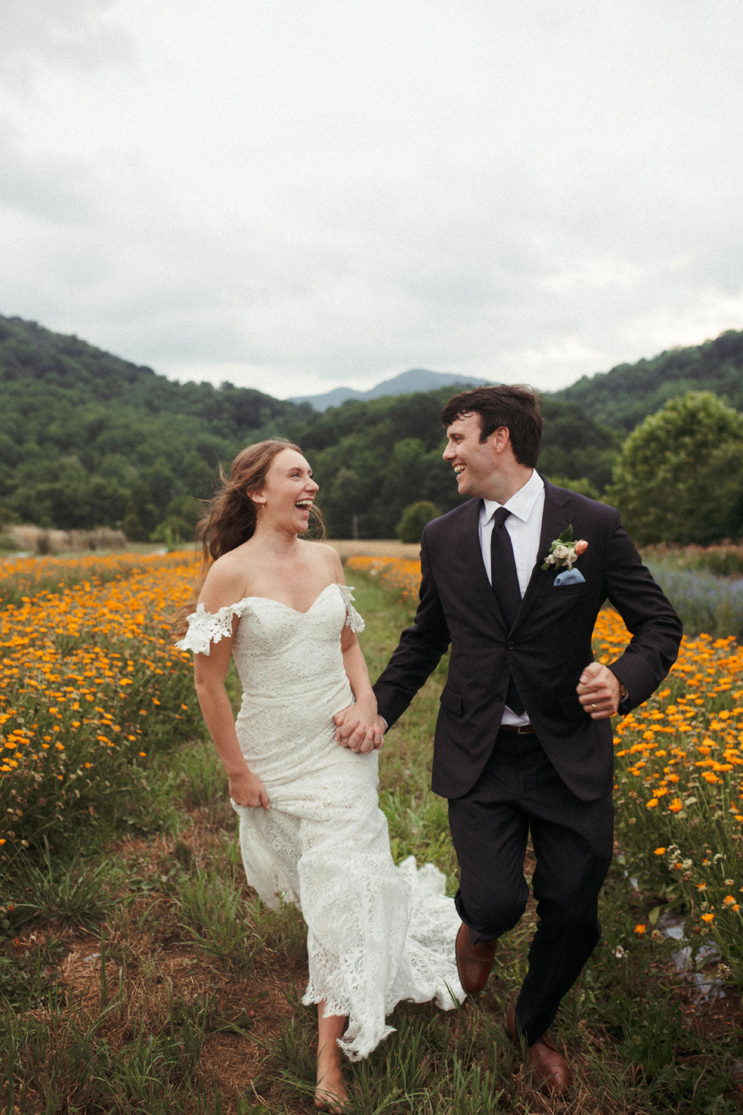 Bride and Groom Running in Wildflower field Wedding protrait