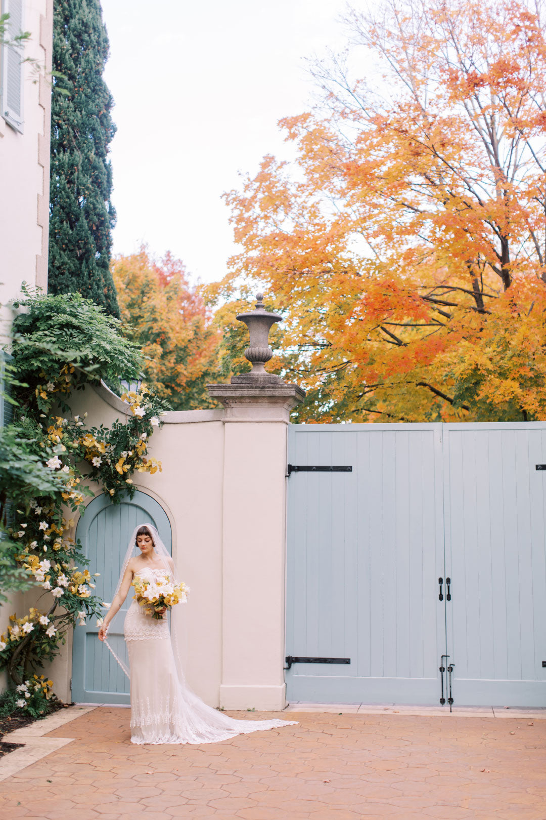 Bride in house courtyard with fall color trees in background