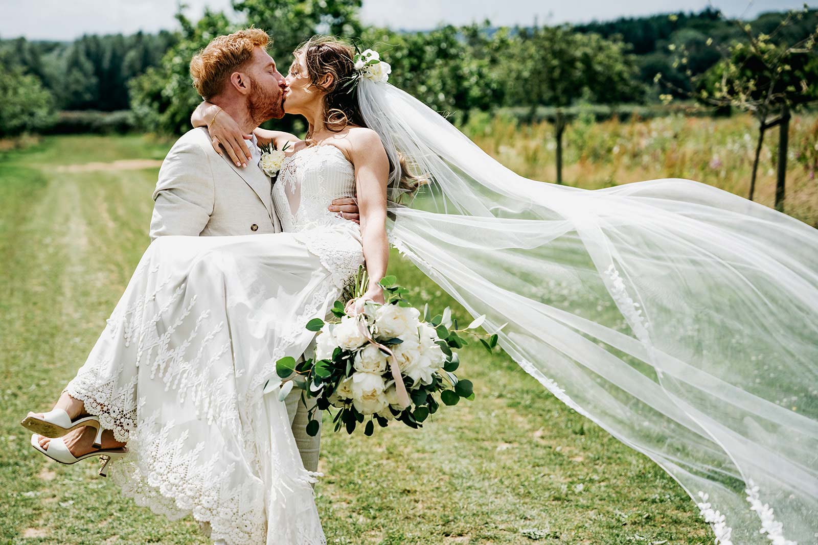 Groom holding bride and kissing 