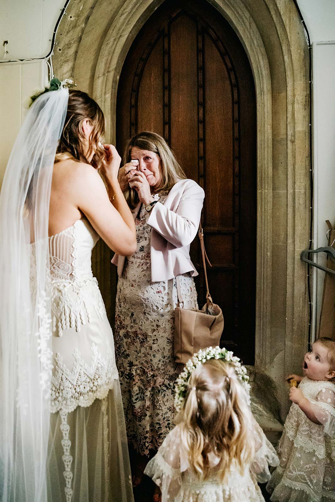 Mother of bride wiping tears before wedding