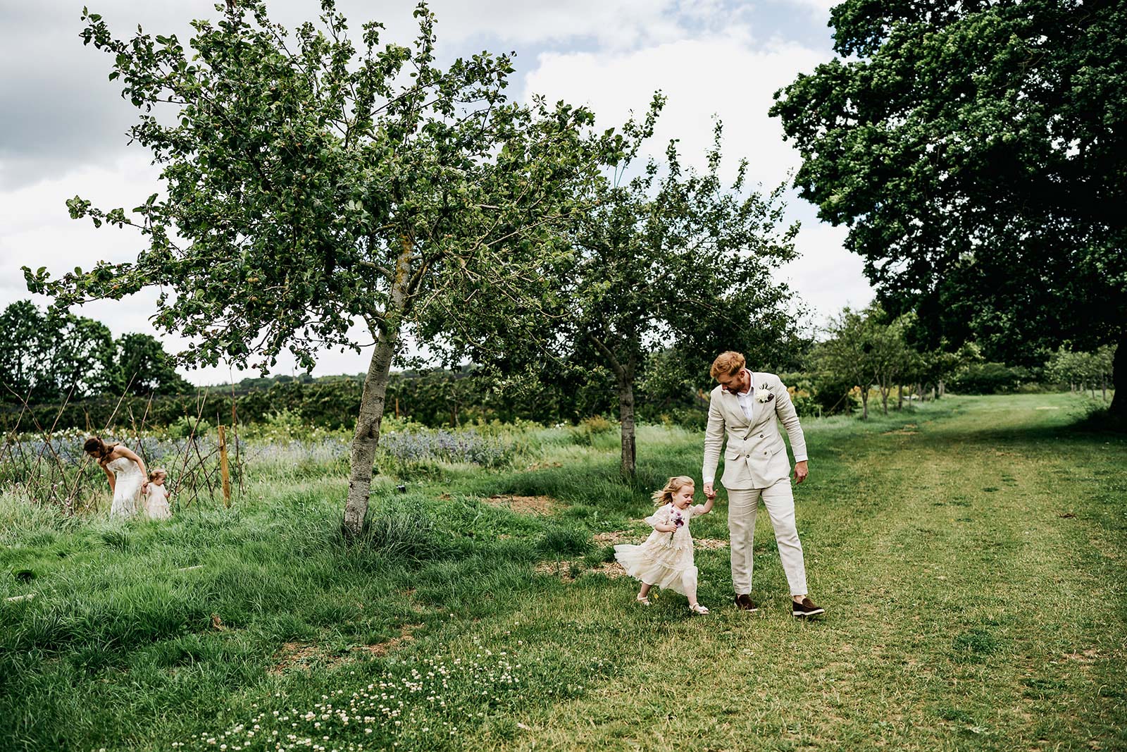 Groom daddy and baby girl walking in field