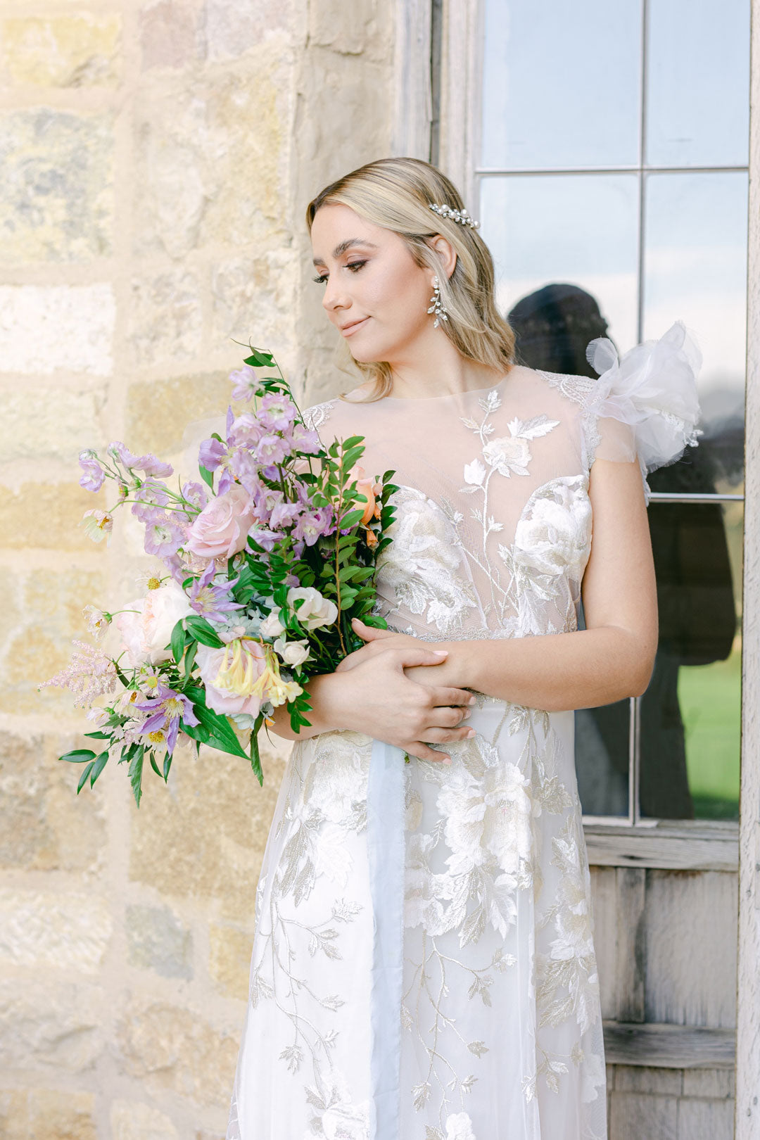 Bride holding wedding bouquet in Chloris by Claire Pettibone