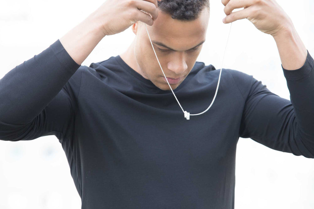 A man putting on a sterling silver necklace