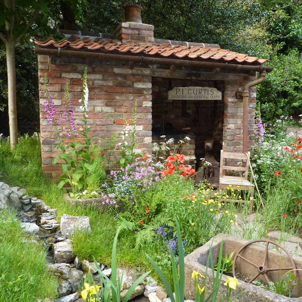 Show Garden with small brick building at Chelsea Flower Show