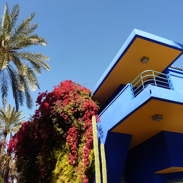 Marjorelle Gardens with blue building, palm trees and borgainvillea