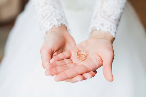 Wedding rings held by bride's hands