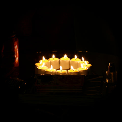 Twelve burning beeswax tea-lights