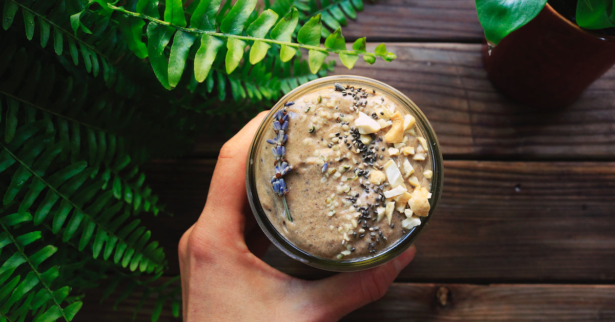 A hands holds a plant-based protein smoothie