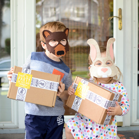 Children dressed in cute felt bunny and bear masks holding their party animal care packages