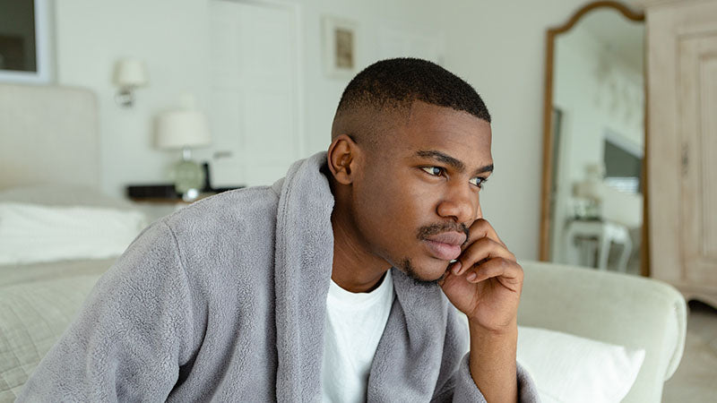 African American man lounging in his bathrobe while on a phone call