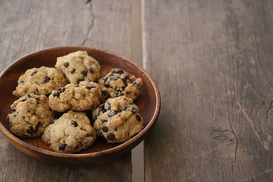 A plate of chocolate chip crackling cookies on a wood table.