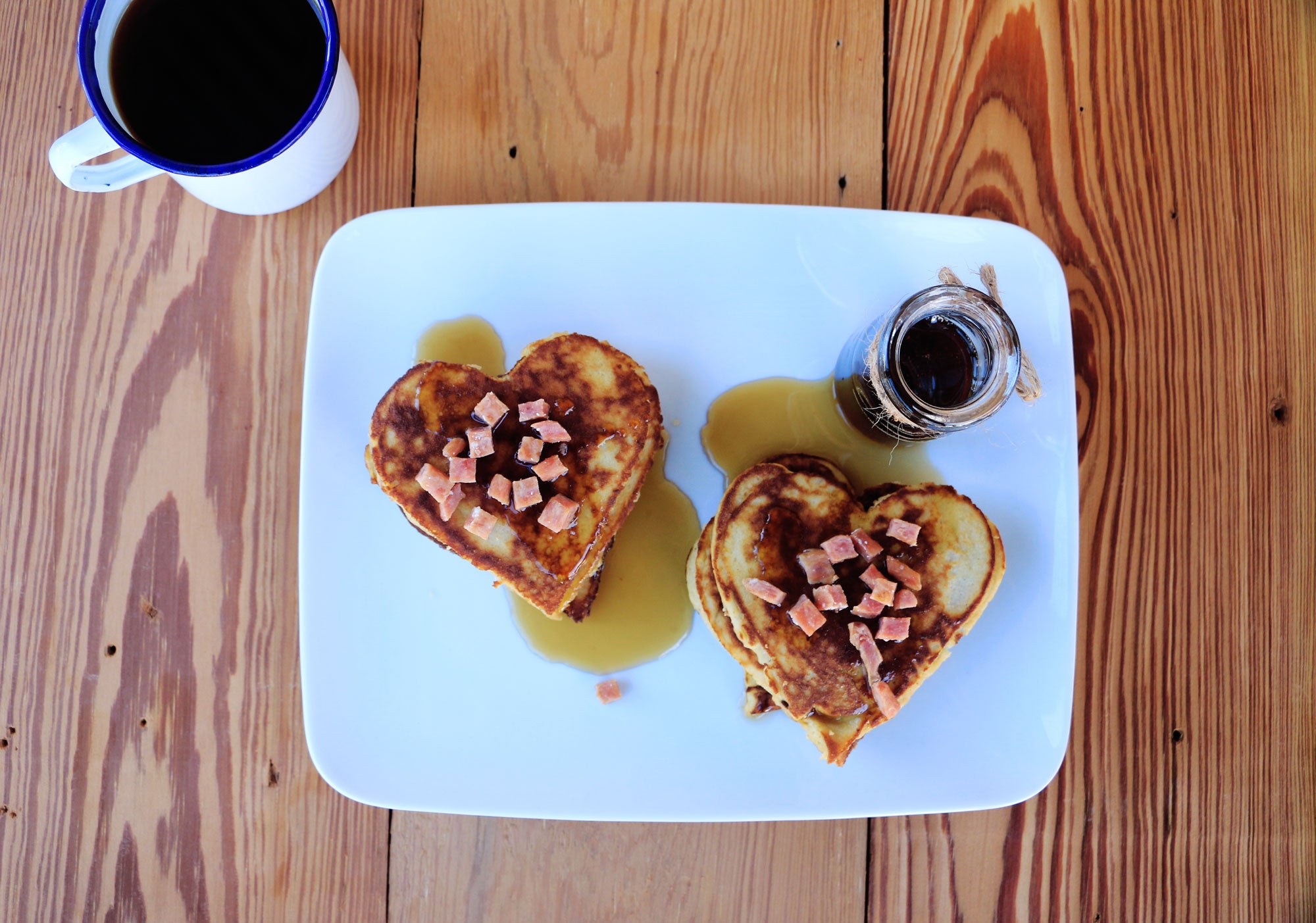 Two stacks of heart-shaped pancakes on a white plate