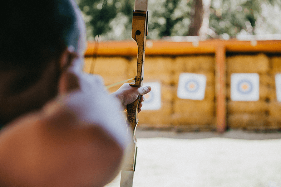 Man shooting arrow at outdoor targets