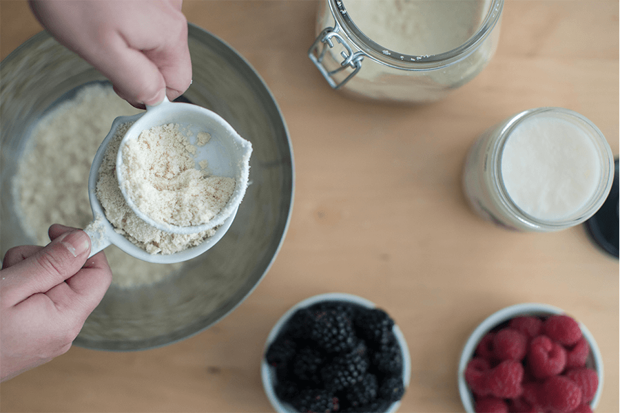 Overhead shot of someone baking with flour, animal fat, and berries