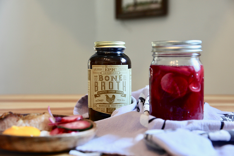 Jar of pickled vegetables sitting next to a jar of epic chicken bone broth.