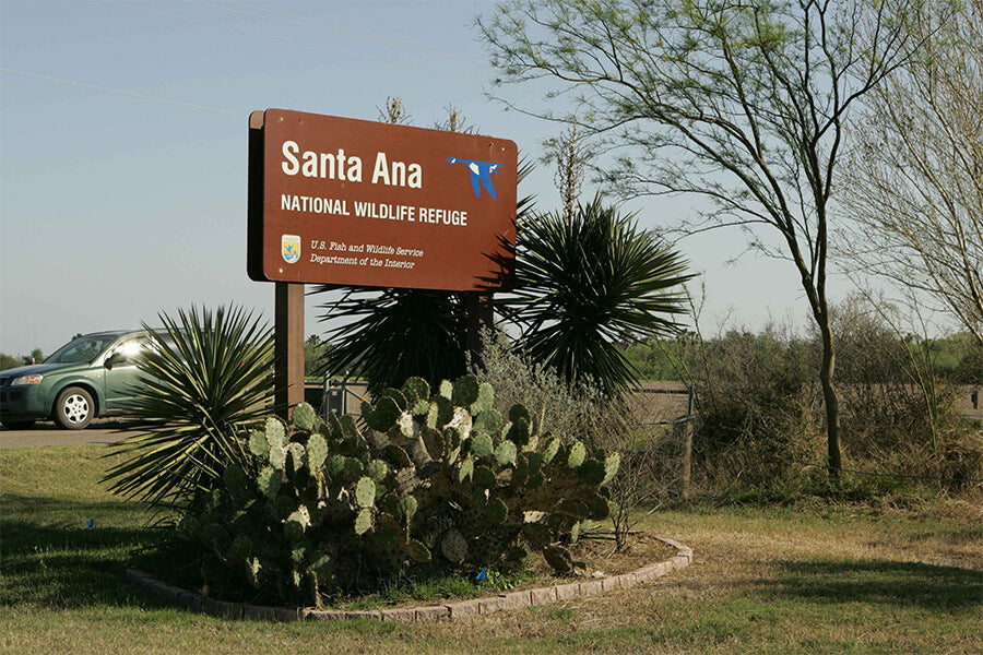 Sign that reads "Santa Ana Wildlife Refuge" in a bed of cacti 