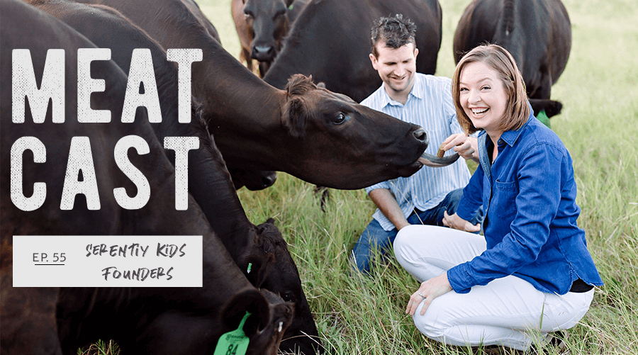 A man and women feeding cows on pasture 