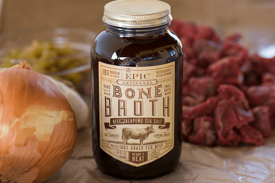 Jar of EPIC beef bone broth with onion and raw stew beef 