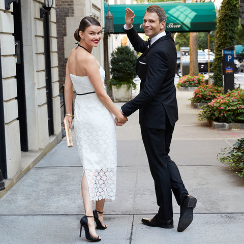 Jane Summers bride in white lace strapless tea length wedding dress with groom in black tux leaving wedding reception