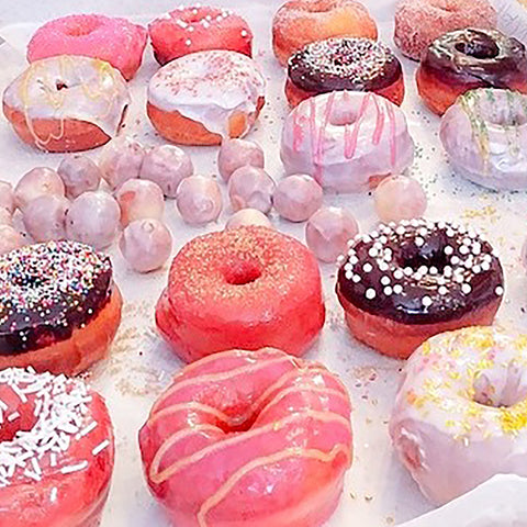Pink glazed and frosted cake donuts with funfetti, striped, sprinkles and sugar
