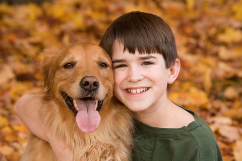 dog with kid in fall leaves
