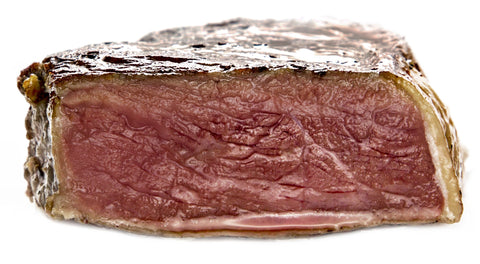 A beautiful steak, rosy from edge to edge, cooked on the Cinder Grill.