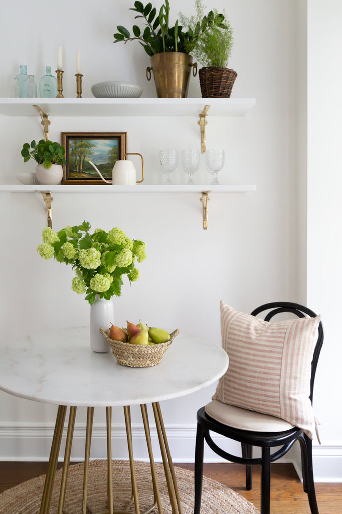 Adena Leigh's breakfast nook with marble bistro table and floating shelves
