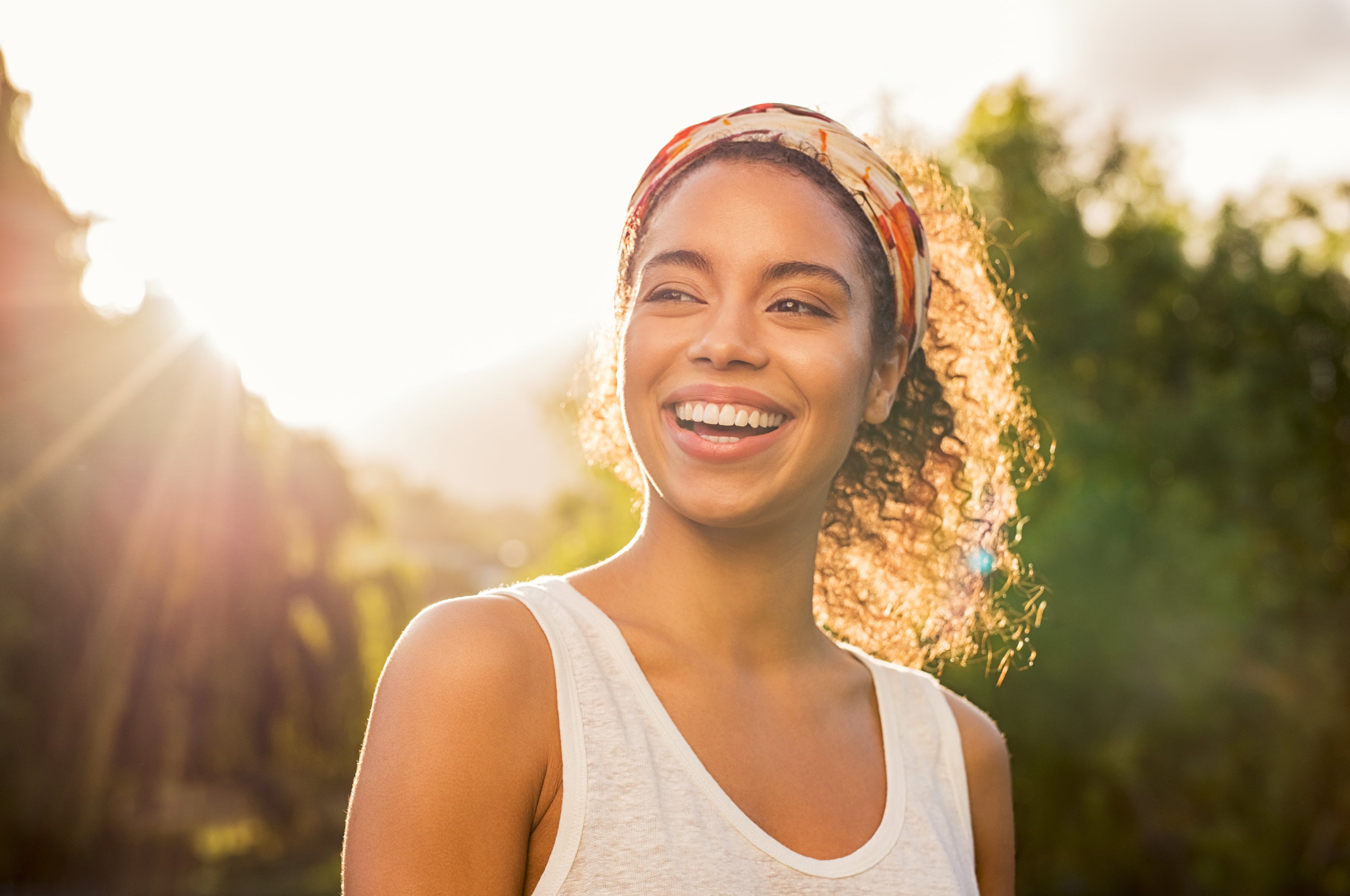 smiling girl with curly hair and headband in sunshine