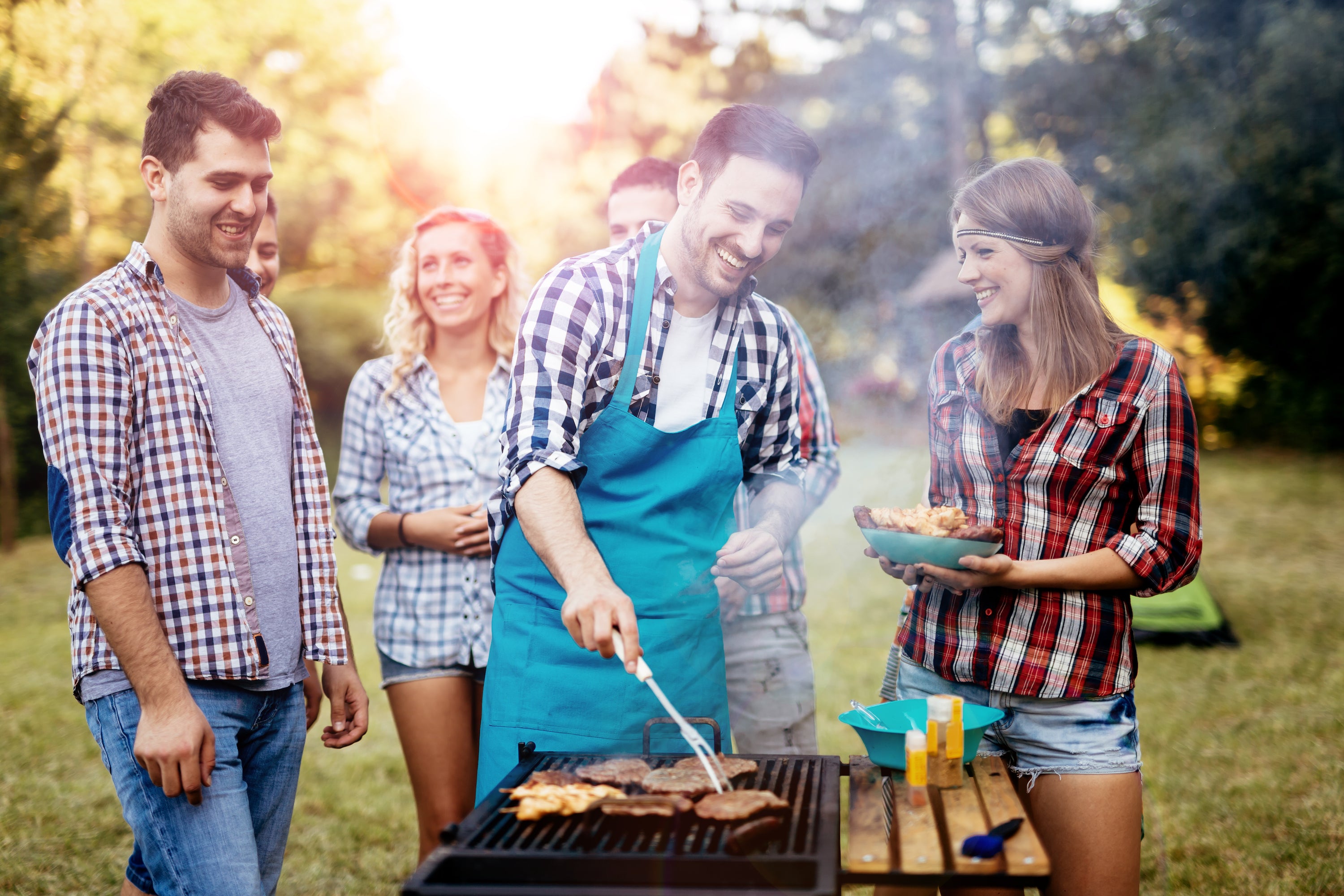 man grilling with friends waiting for food