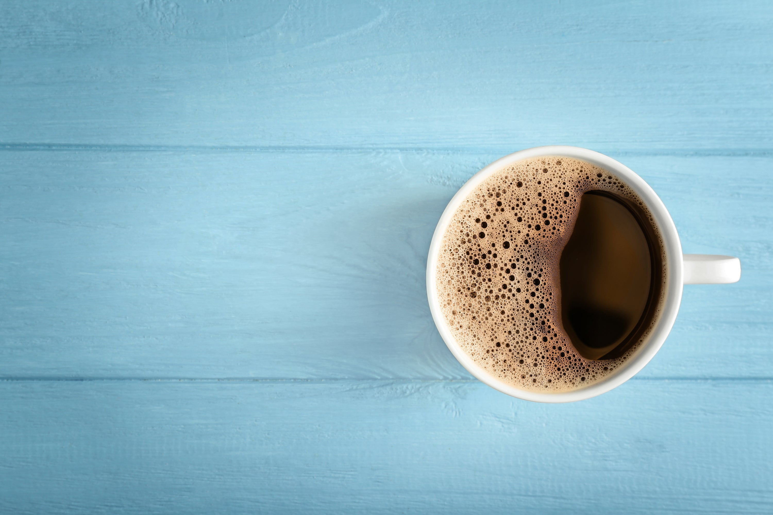 cup of black coffee on blue wooden table