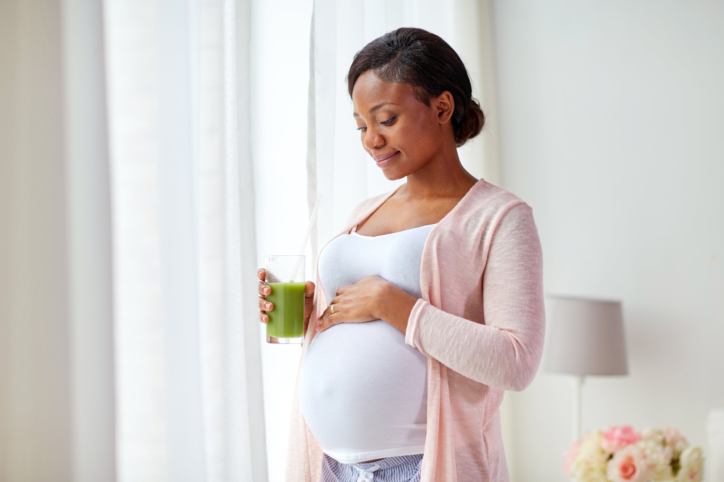 pregnant woman holding green juice