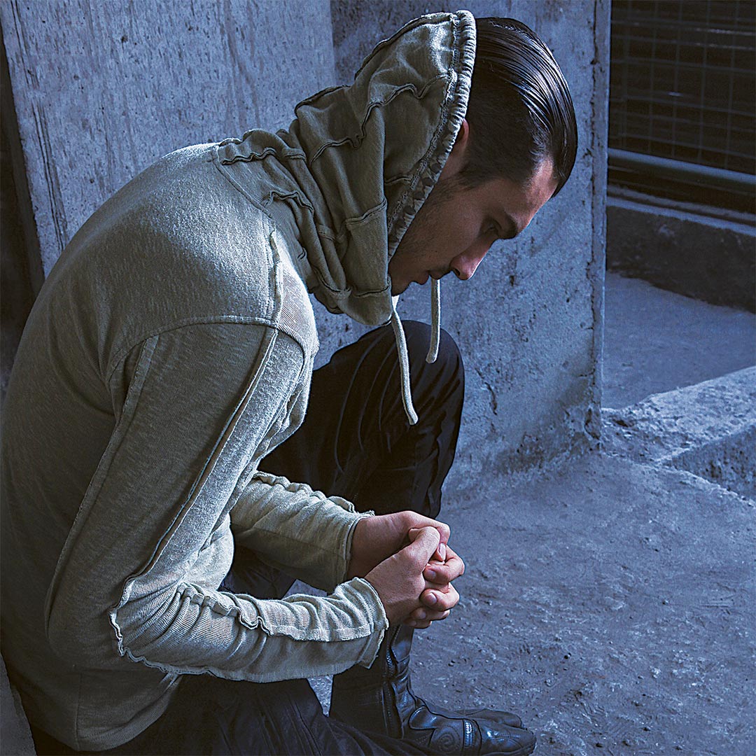 Man sitting wearing Psylo fashion ethical streetwear sweater hoodie