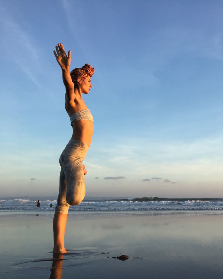 Selina practicing beach yoga