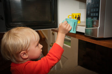 Toddler putting Kid-Sized Mug in the Microwave